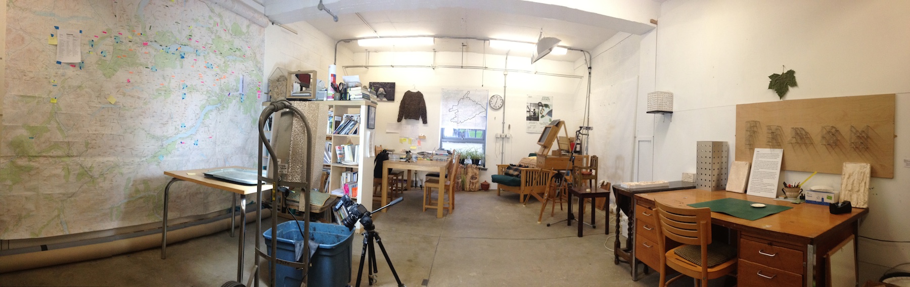 Panoramic view of Collins and Goto's art studio, featuring desks, books, and works in progress.